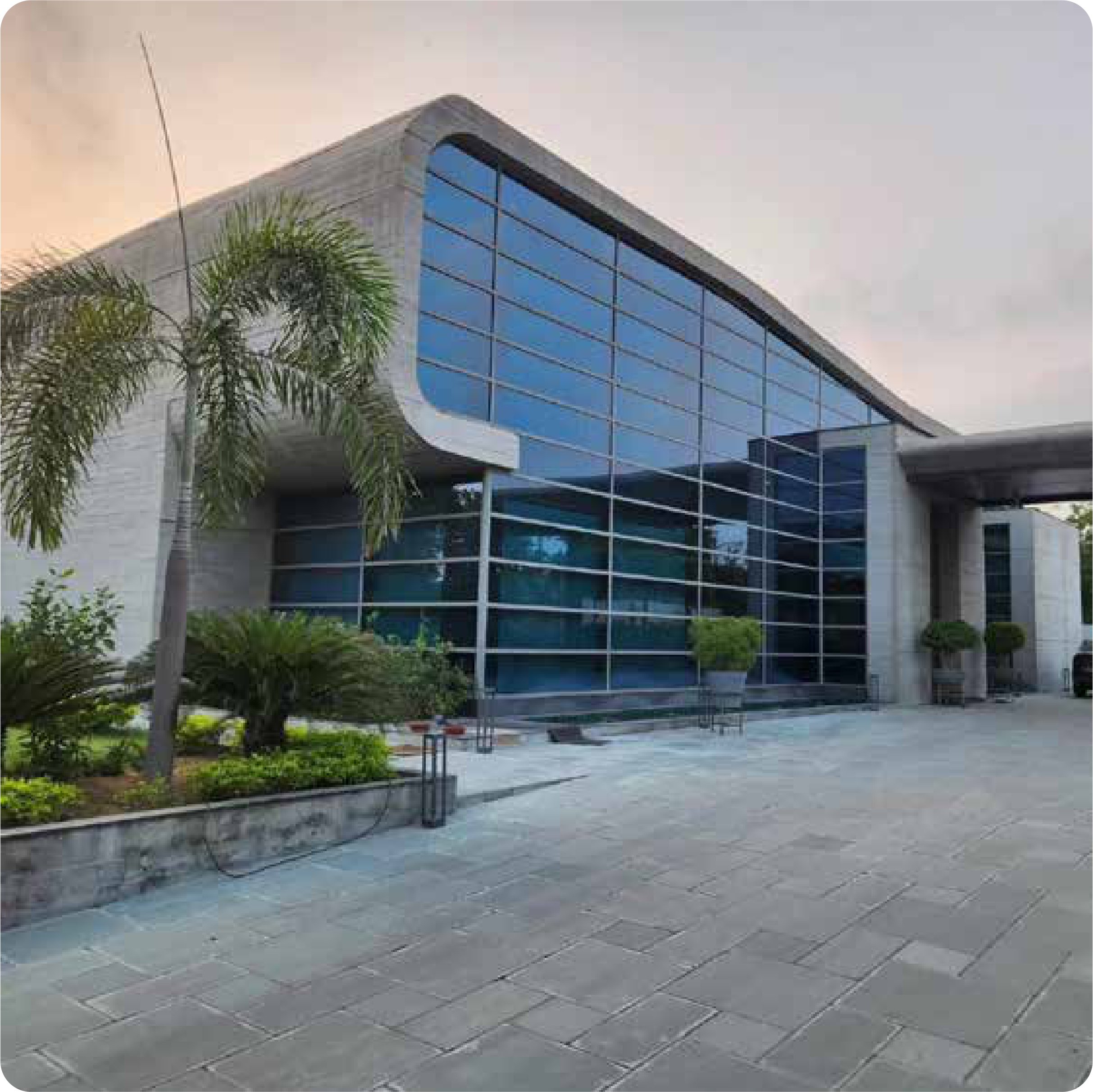 Contemporary corporate building with curved concrete roofline, completed by YogeeNi Infracon in Ahmedabad